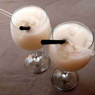 2 calici con cocktail di Meritene Mobilis con cannuccia trasparente, stecco di liquirizia e cubetti di ghiaccio